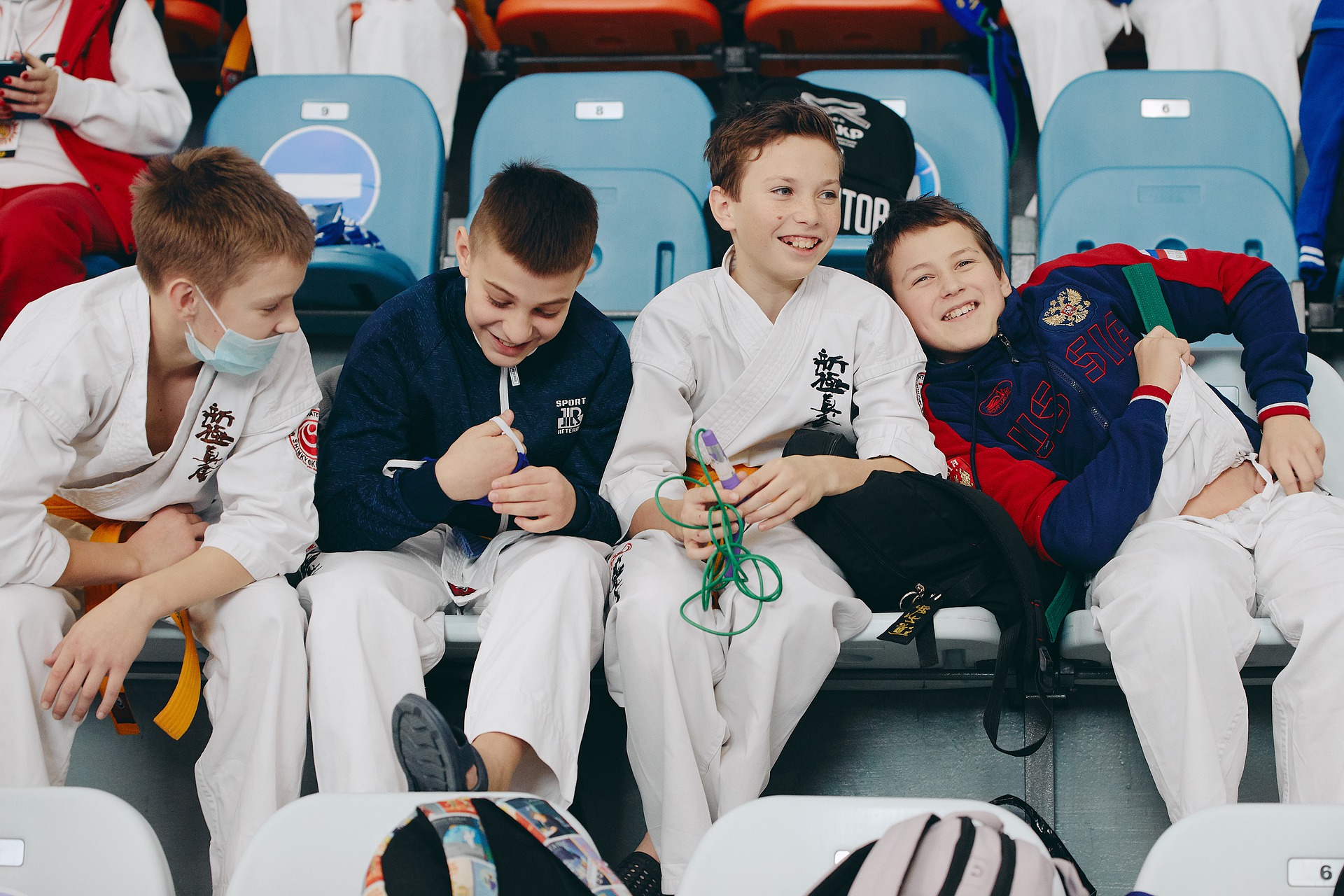 four boys sitting at a karate event